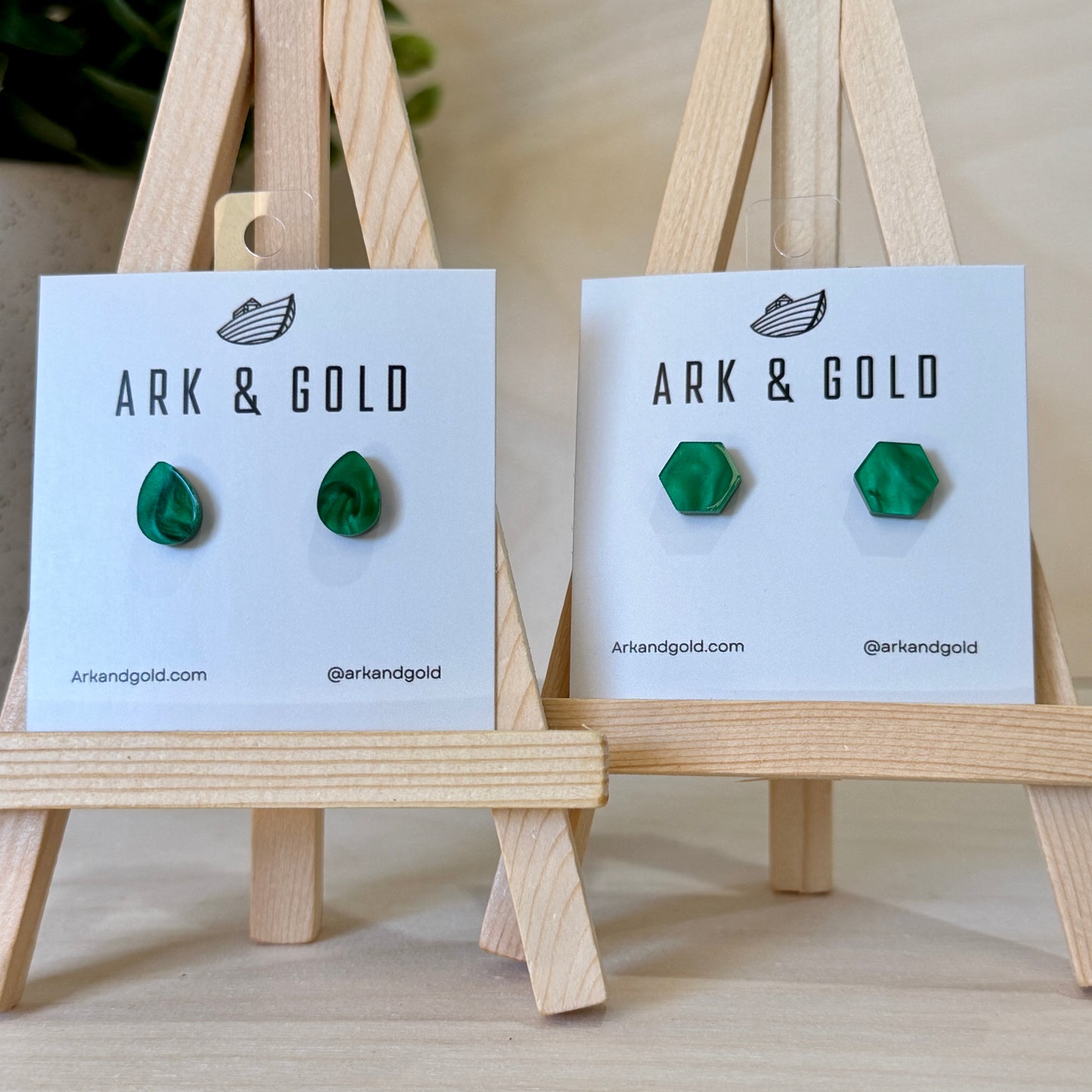 Green earrings on Ark & Gold branded cards with wooden stands.