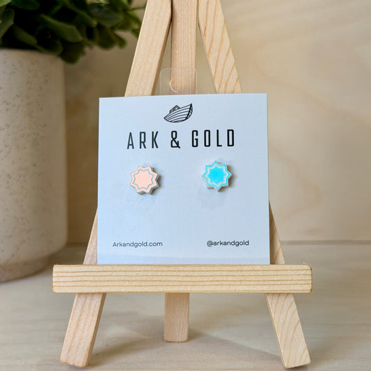 Pair of earrings on a 'ARK & GOLD' branded card with a wooden stand.